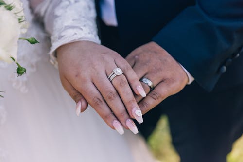 A Person with Pink Nails Wearing Diamond Wedding Ring