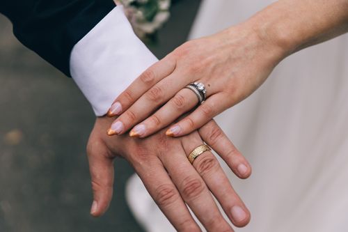 Free A close-up shot of a couple's hands with wedding rings, symbolizing love and marriage. Stock Photo