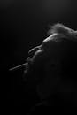 Grayscale Photo of a Man Smoking a Cigarette