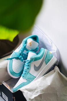 Close-up of stylish Air Jordan sneakers in vibrant turquoise and white with a Nike logo on display.