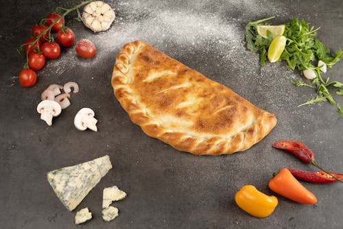 Free A Delicious Folded Pizza on Gray Surface Stock Photo