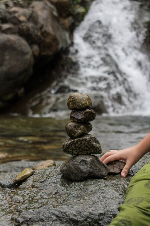 A Person Sitting Beside Piled Stones