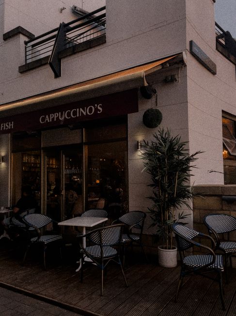 Cozy outdoor café setting with empty chairs and tables, inviting ambiance.