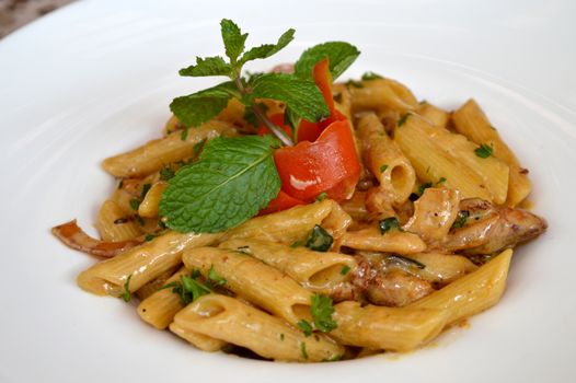 Appetizing creamy pasta with fresh herbs and vegetables, perfect for food photography.
