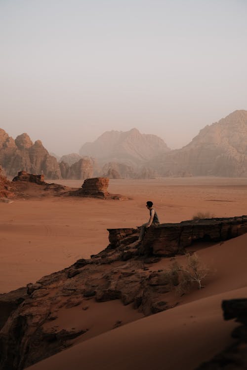 Man Sitting on a Rock in the Wadi Rum Valley in Jordan 