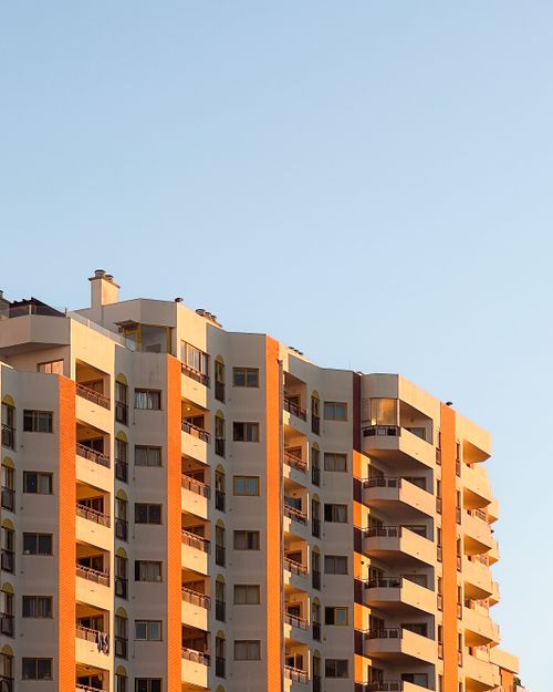 Free Sunlit apartment building exterior in Portimão, Portugal at golden hour. Ideal for real estate and architecture themes. Stock Photo