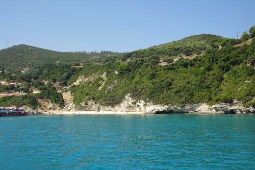 Foto d'estoc gratuïta de a l'aire lliure, aigua blava, arbres verds