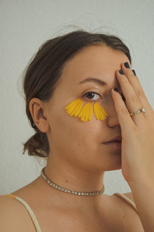 Close-up Photo of Beautiful Woman with Yellow Petals under her Eye