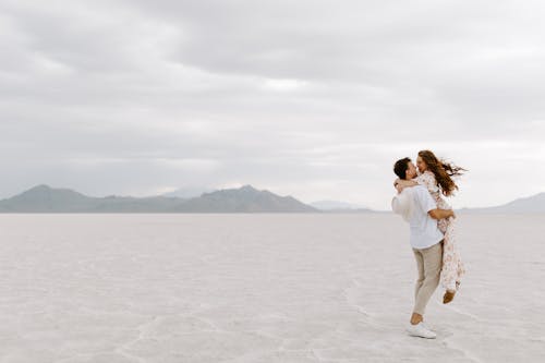 Free Happy Couple Hugging on a White Sand Desert  Stock Photo