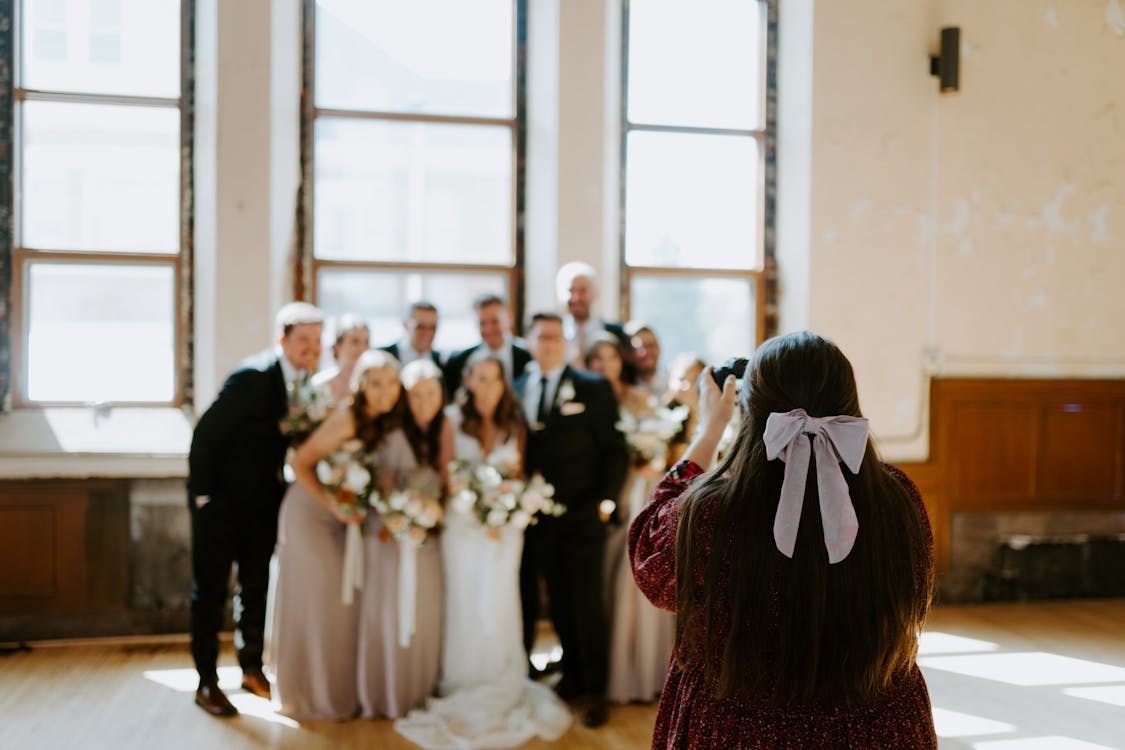 Woman takes a group photo of a wedding.