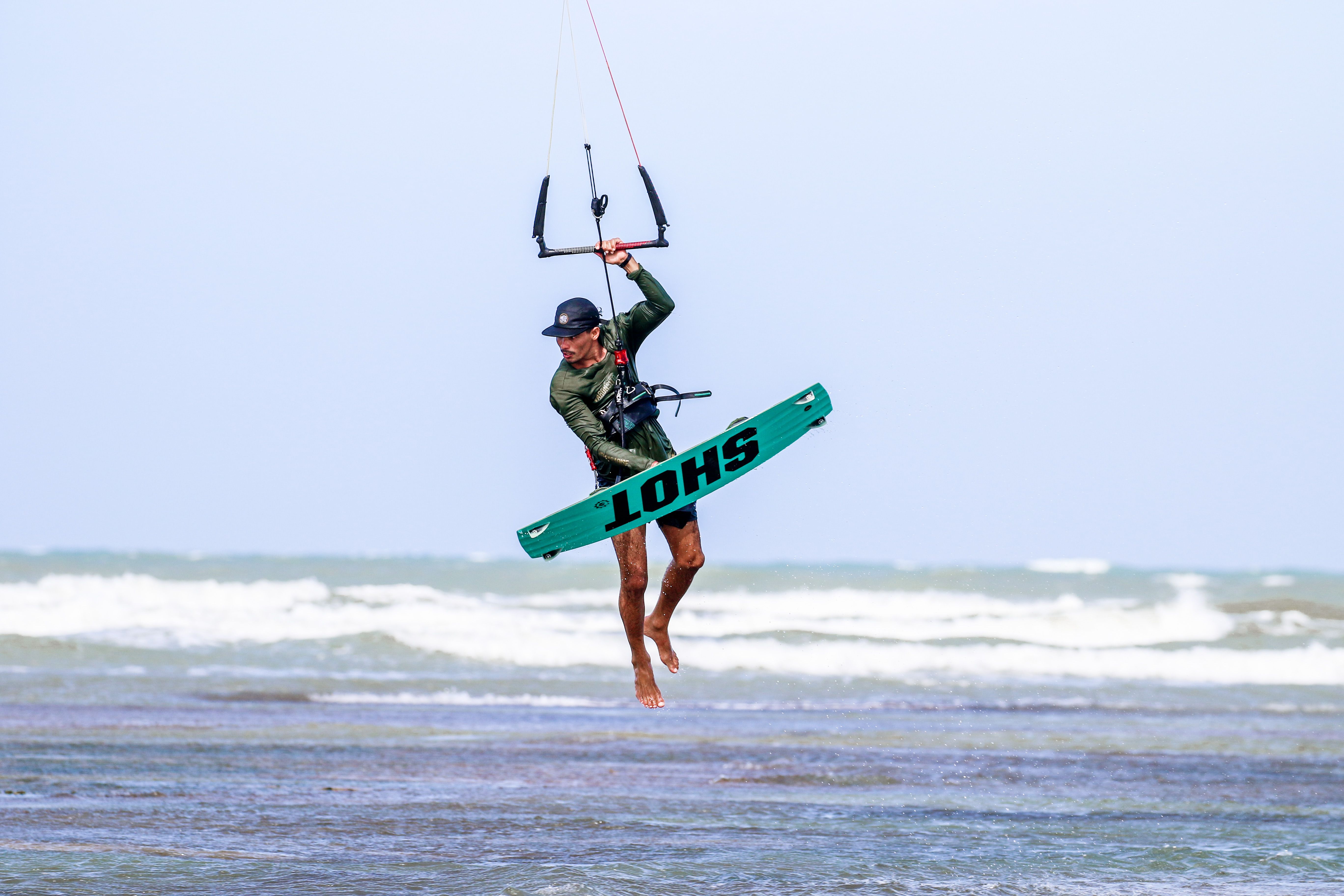 Kitesurfer catching air above the waves in Adicora, Venezuela, showcasing watersport excitement.
