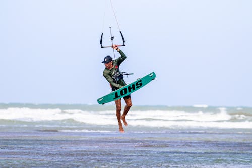 A Man Kitesurfing on the Beach
