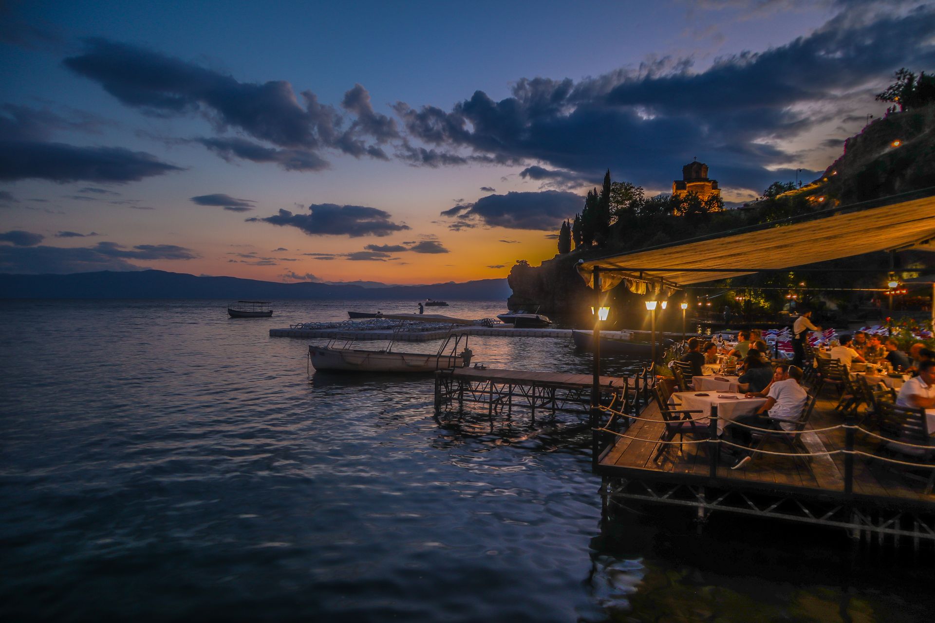 People In A Restaurant Beside Body Of Water