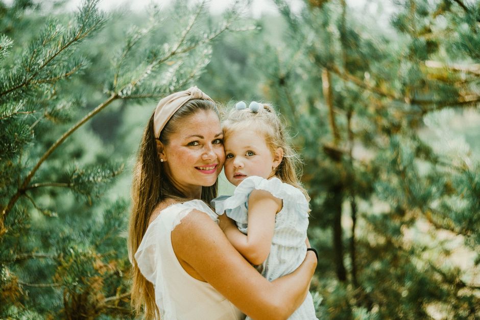 Heartwarming portrait of a mother and daughter sharing a tender moment outdoors.