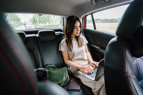 女人在車內使用便攜式計算機