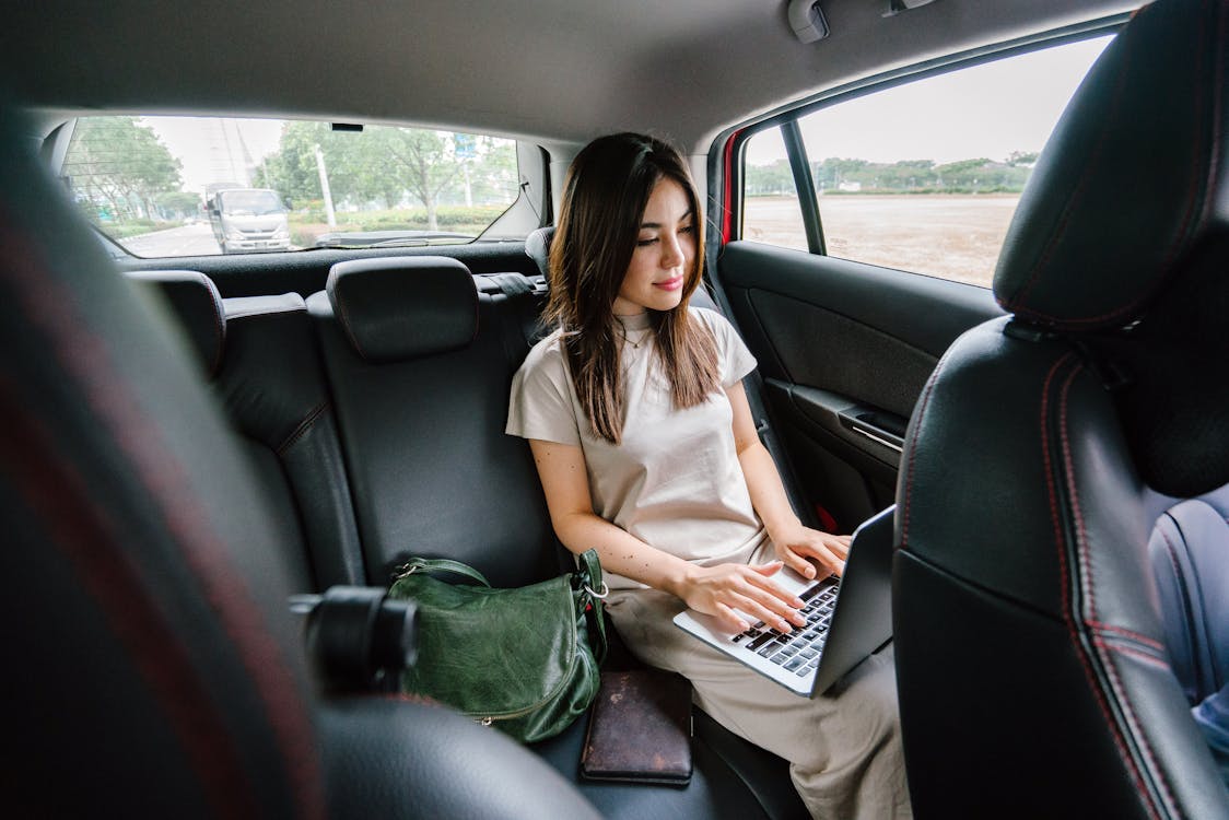車内でラップトップコンピューターを使用している女性