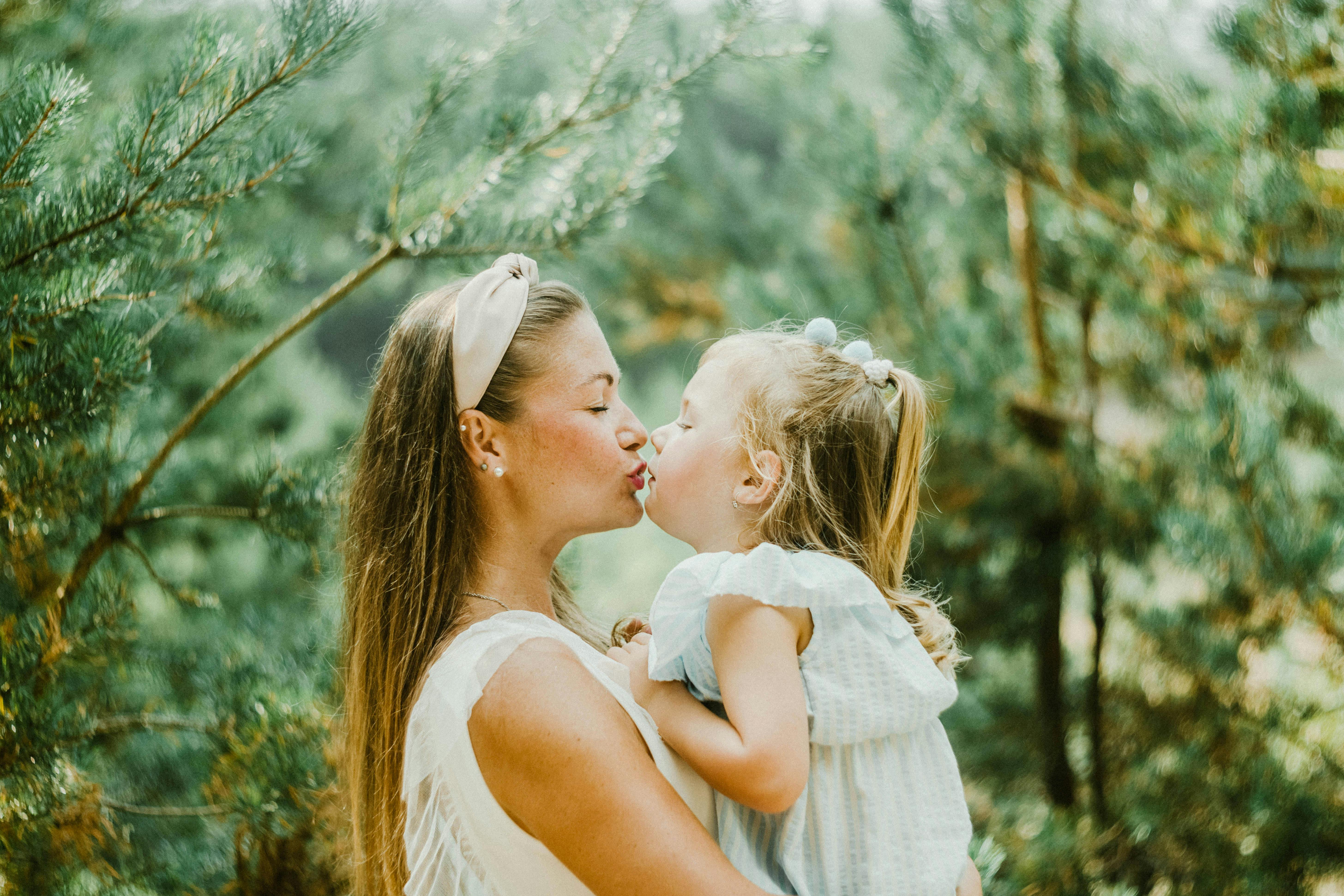 A parent kissing their child 