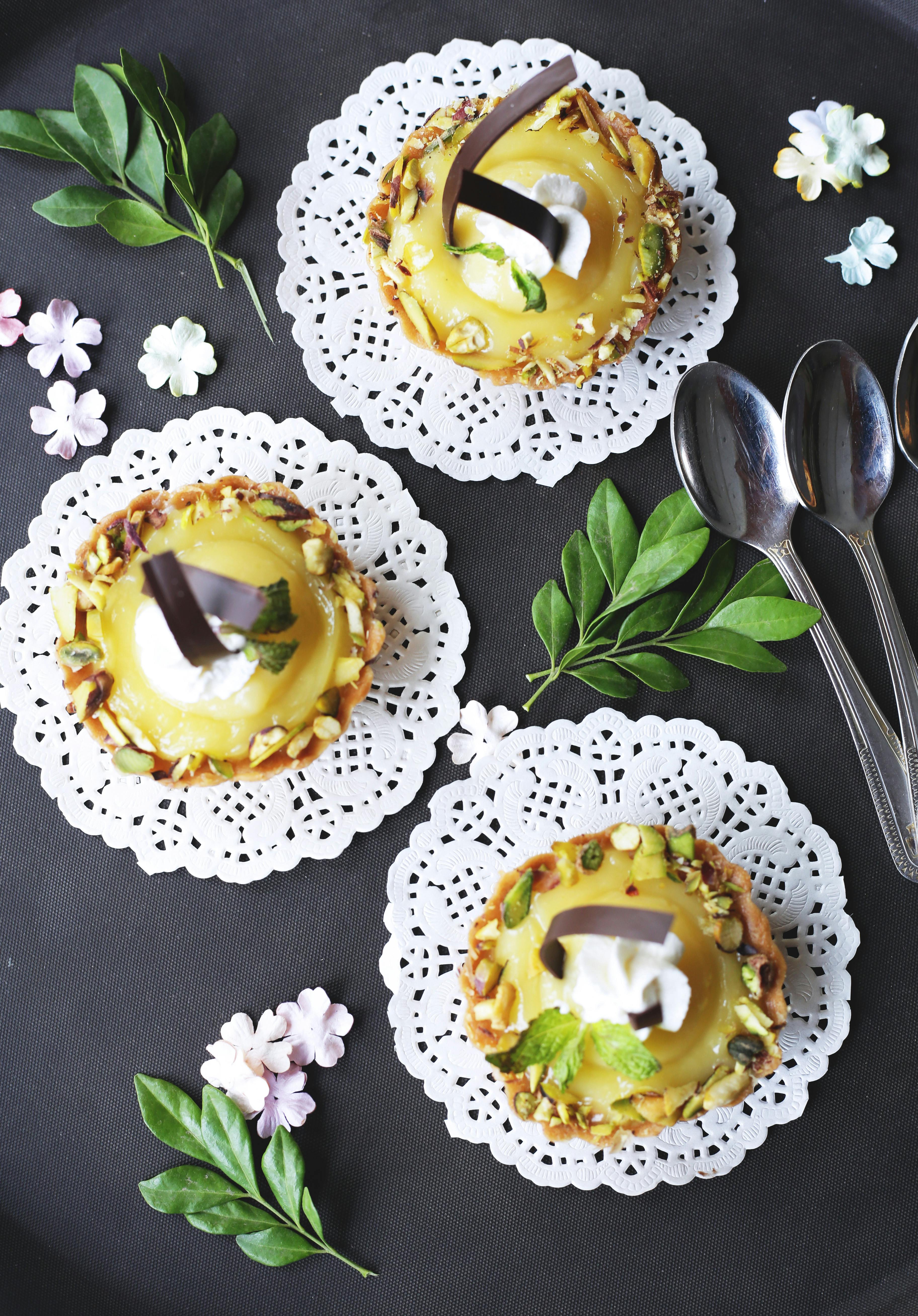 柠檬馅饼的顶视图，上面装饰着生奶油，桌布上还点缀着坚果