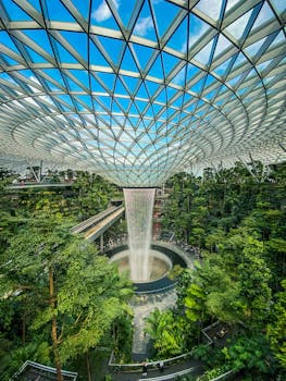 Spectacular indoor waterfall at Jewel Changi Airport surrounded by lush greenery.