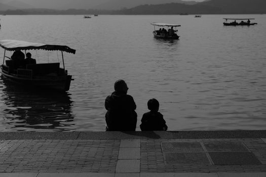 Silhouette of 2 Person Sitting on Dock