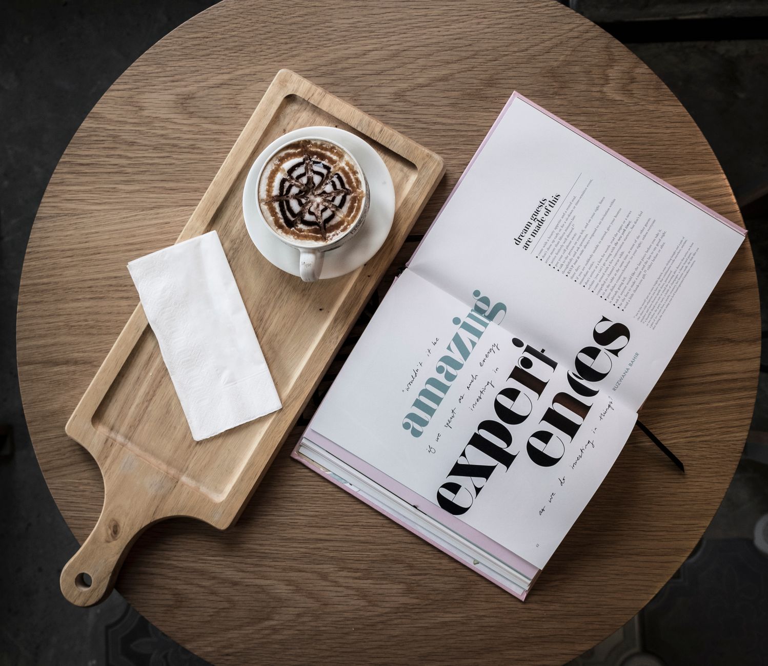 A cup of coffee beside an open book on a quiet breakfast table