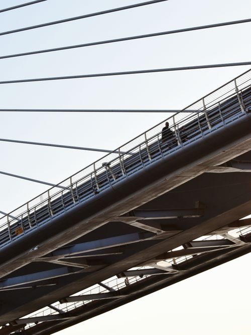 Free A low angle view of a modern suspension bridge in Turkey with a person walking across. Stock Photo