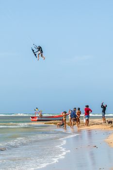 Kitesurfer catching air while spectators watch on the beach in Adicora.