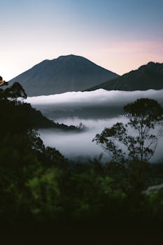 Breathtaking view of misty mountains and lush nature in Bali, Indonesia at dawn.