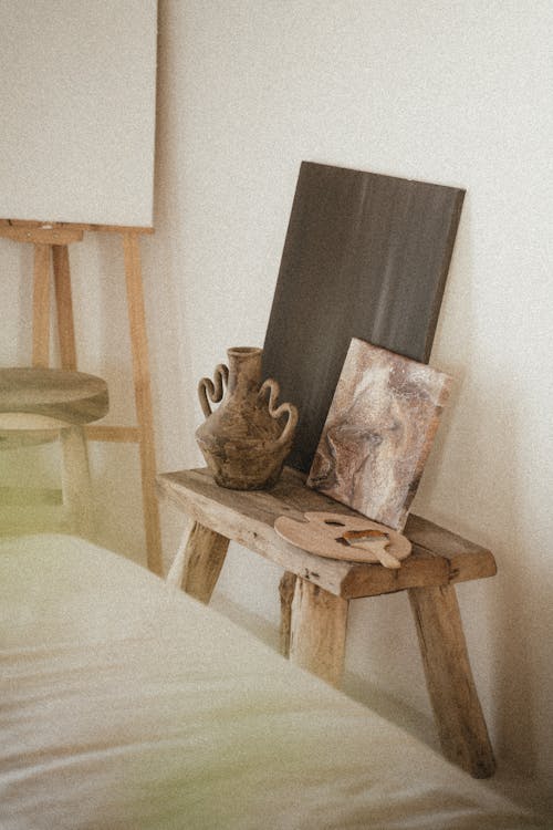 Free Paintings and a Clay Jar on Wooden Stool Stock Photo