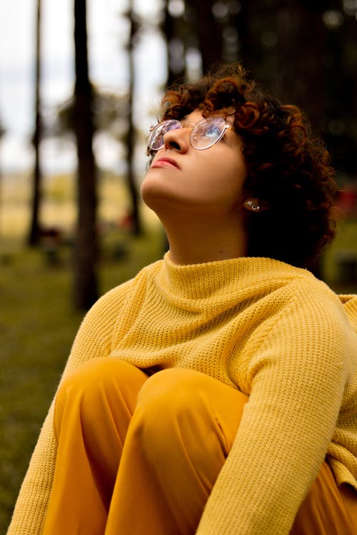A Woman in a Knitted Yellow Sweater Looking Up