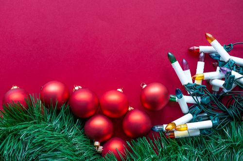Free Colorful Christmas lights and red ornaments on a festive background. Stock Photo