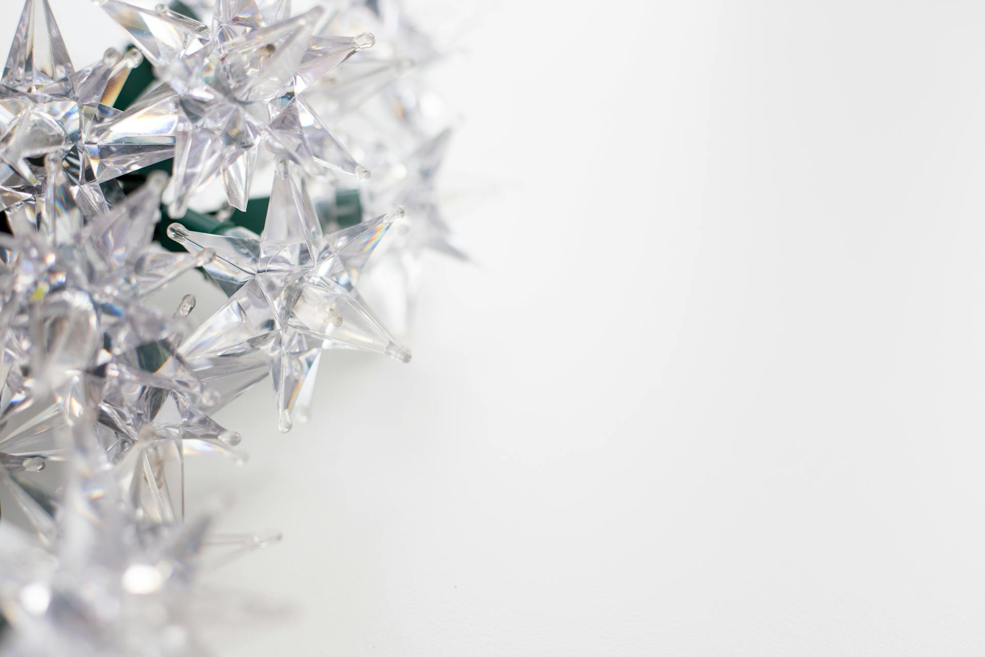 Close-up of glittering crystal star decorations on a white background for festive designs.