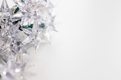 Free Close-up of glittering crystal star decorations on a white background for festive designs. Stock Photo