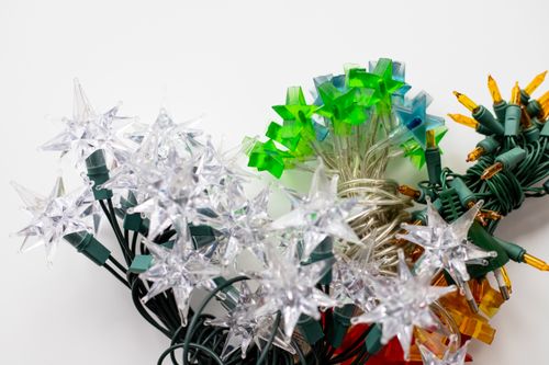 Free Bright and colorful star-shaped Christmas lights with clear, green, and orange bulbs. Stock Photo