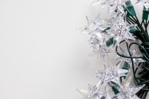 Free Close-up of star-shaped string lights on a white background, perfect for festive decor. Stock Photo