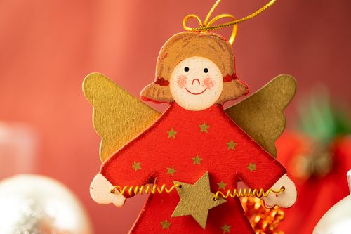 Free Close-up of a handmade Christmas angel ornament with golden wings and red dress. Stock Photo