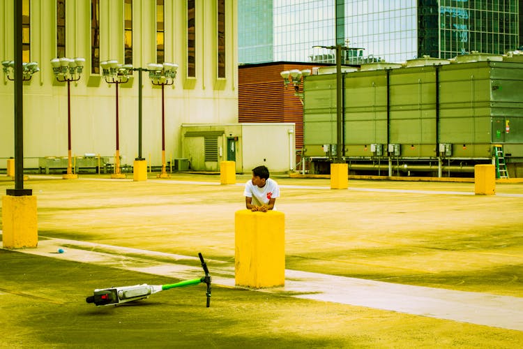 Photo Of A Man On A Street With An Electric Push Scooter Lying On The Pavement 