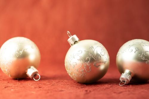 Free Elegant gold Christmas baubles with intricate designs on a red backdrop. Stock Photo