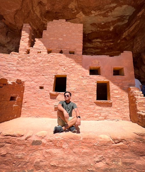 Man Sitting in front of the Building in Cliff Palace, Colorado, USA