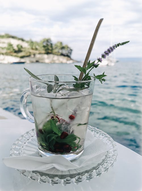 Cold Drink in a Glass on the Table with the Sea in the Distance 