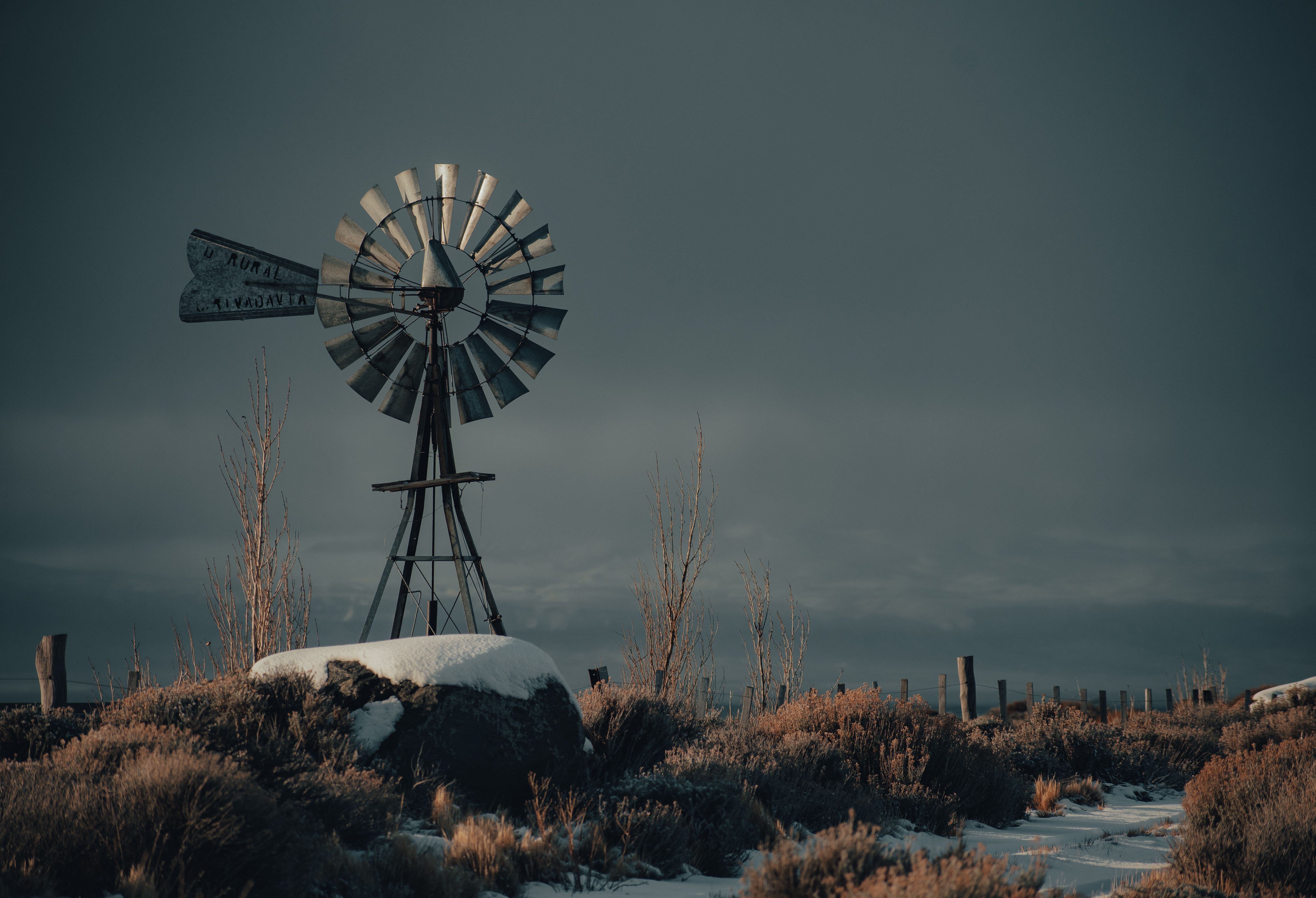 A scenic winter landscape featuring a rustic windmill surrounded by snow and a serene countryside atmosphere.