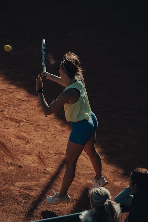 Free Woman in White Shirt and Blue Shorts Playing Tennis Stock Photo