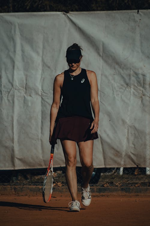Female Tennis Player in Sportswear holding a Tennis Racket 