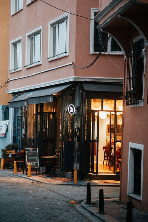 Free Charming street corner restaurant with warm lighting, inviting atmosphere. Stock Photo