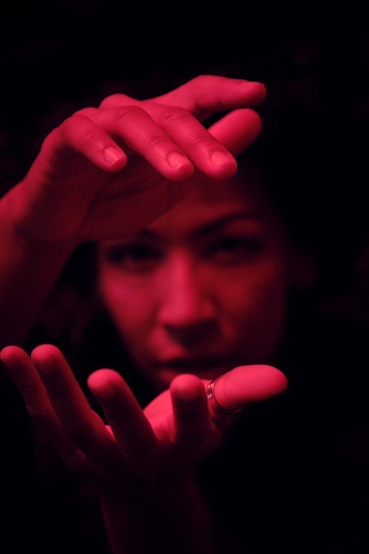 Face Of A Woman Gesturing In A Dark Room