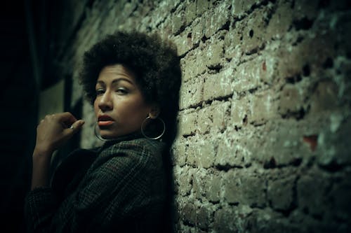 Portrait of a Young Woman Leaning on a Brick Wall