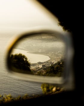 Scenic view of Ténès coastline reflected in a car side mirror, showcasing Algeria's serene beauty.