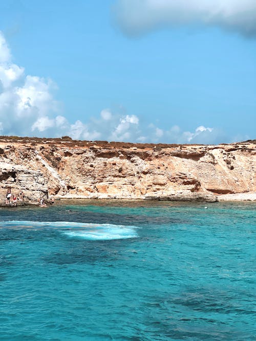 Rock Formation on Seaside under Cloudy Sky 