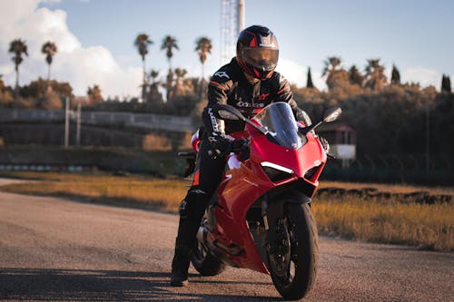 A Man Riding a Red Ducati Motorcycle while Wearing Helmet