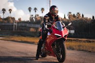 A Man Riding a Red Ducati Motorcycle while Wearing Helmet